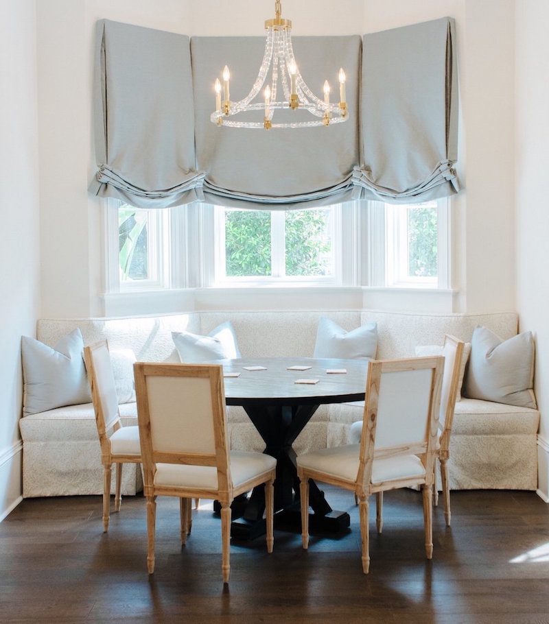 Design Loves Detail found on Ave Home - round dining tables with banquette and Louis XVI style chairs - Roman Shades