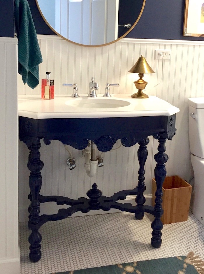 painted antique table in a bathroom used as a vanity