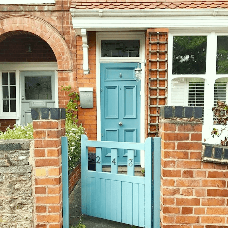via door_doork on instagram blue-green door with red brick house