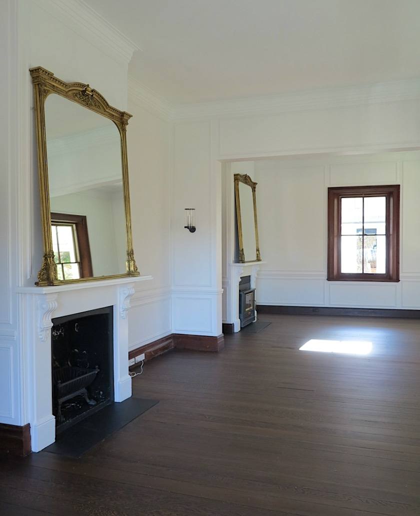 Rosedale Farm living room - empty - gold framed mirrors - white walls - dark brown stain window casing