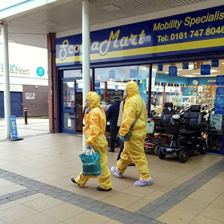 image: Kennedy News and Media - Couple shopping holiday shopping gifts for2020in full hazmat suits